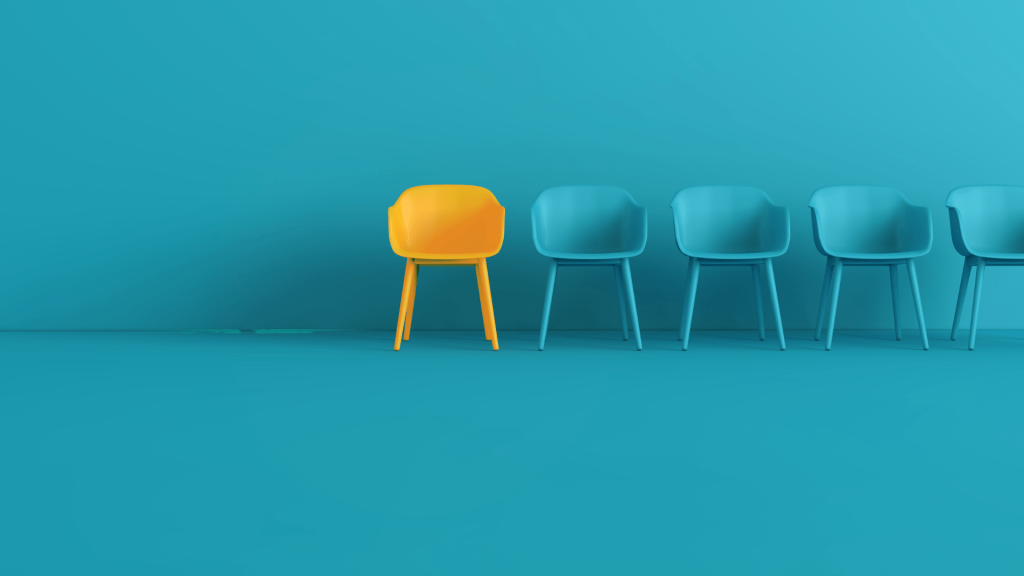 5 blue empty chairs with one orange representing financial advisor recruitment