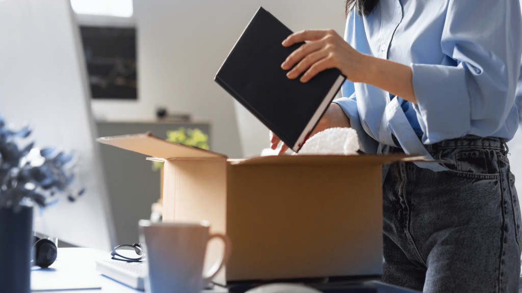 a woman packing up her desk while changing careers to become a financial advisor