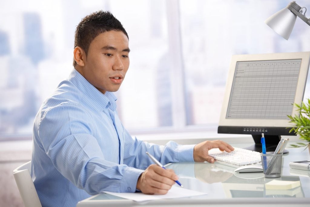 Man sitting at the a desk with a computer.